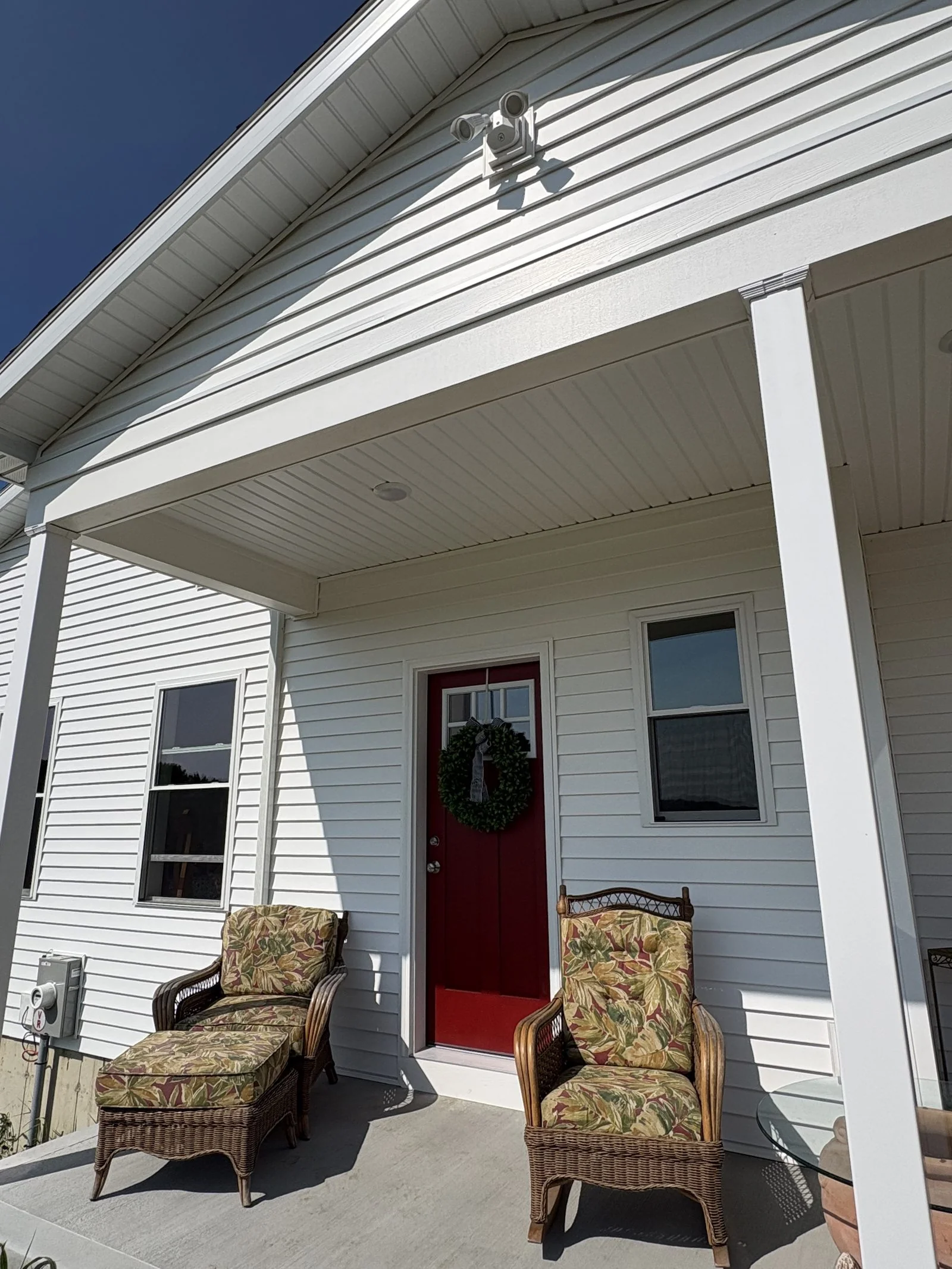 Covered porch entry with red front door